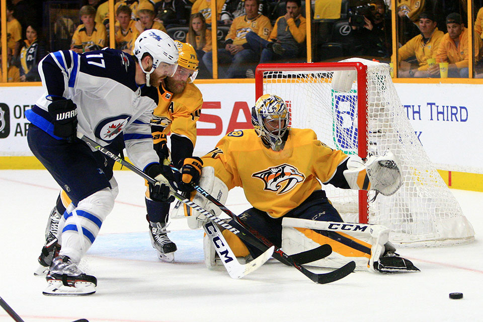 Nashvilles Torwart Juuse Saros beobachtet das Duell zwischen Mitspieler Mattias Ekholm und Winnipegs Adam Lowry.