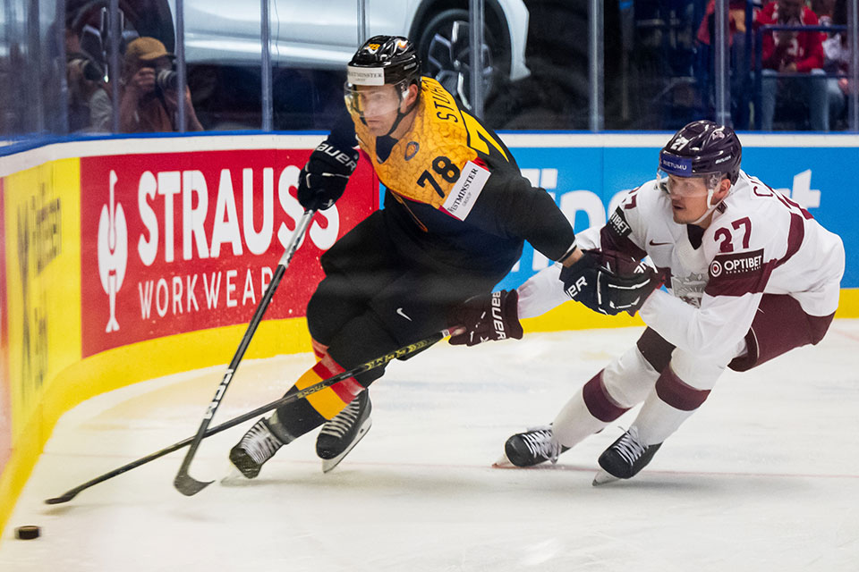 Nico Sturm von Team Deutschland fhrt den Puck vor Oskars Cibulskis von Team Lettland.