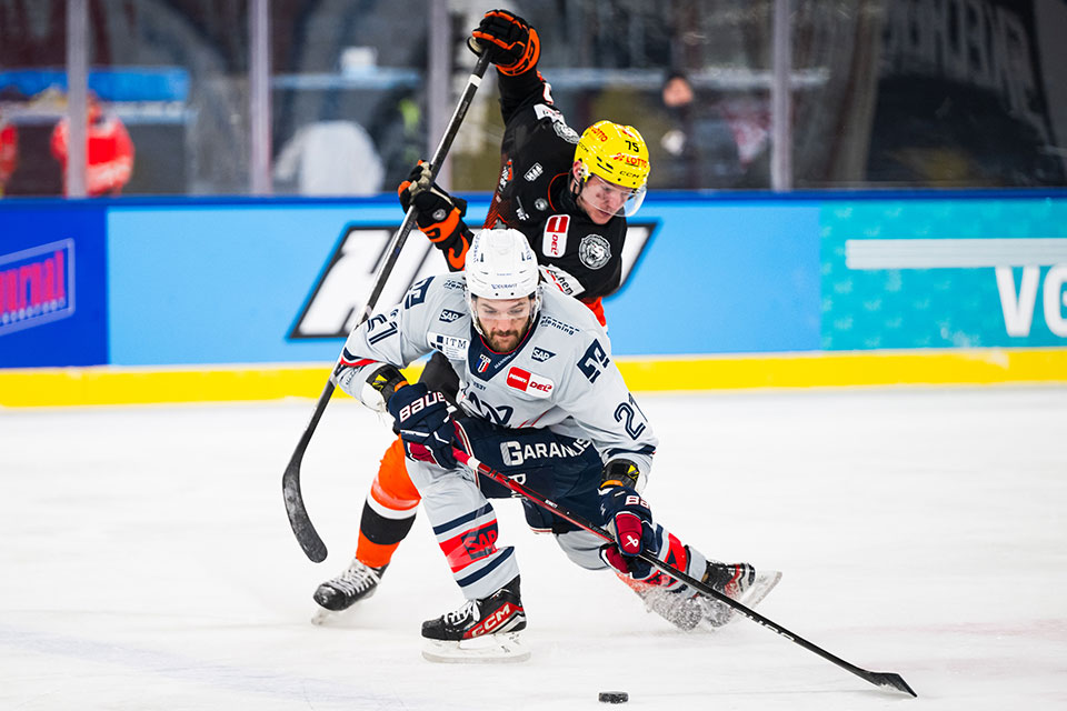 Julian Napravnik von den Löwen Frankfurt und Kris Bennett von den Adler Mannheim im Zweikampf.