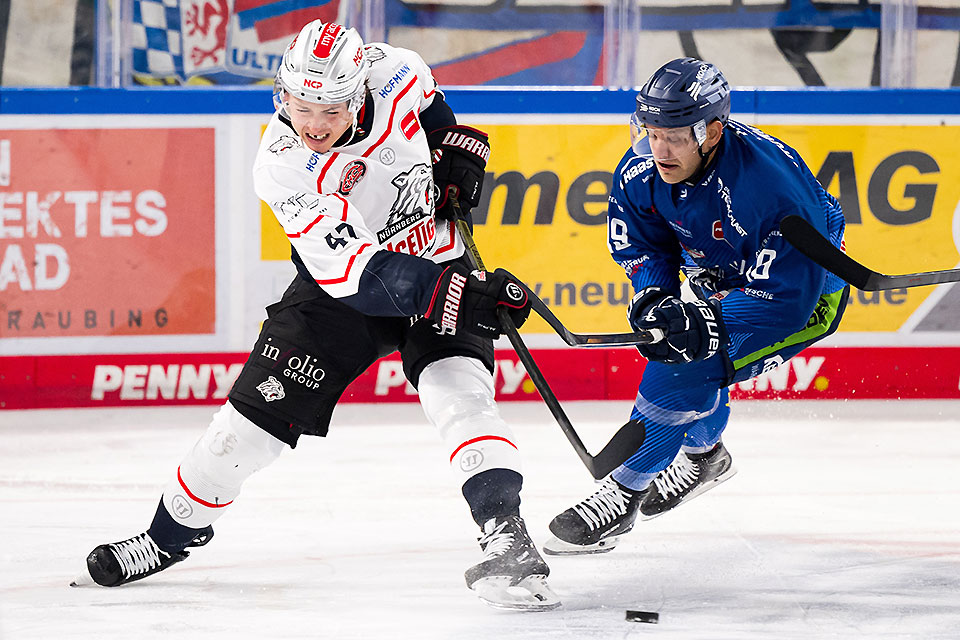 Owen Headrick von den Nrnberg Ice Tigers schiet den Puck vor Tim Brunnhuber von den Straubing Tigers